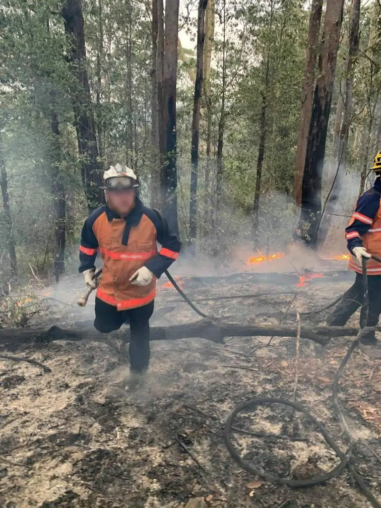 Crew working the edge of a burn in bushland.